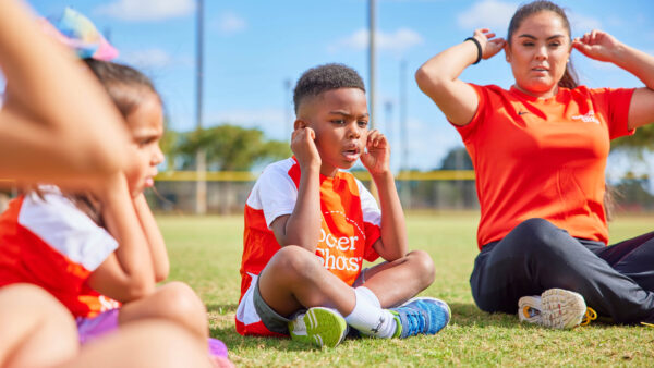 Soccer Shots coach with kids showing listening ears
